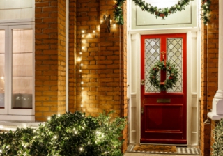 a red front door with christmas wreath